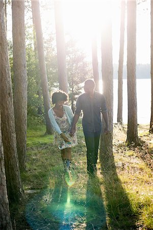 A happy couple in a shady spot in woodland in summer. Fotografie stock - Premium Royalty-Free, Codice: 6118-07351606