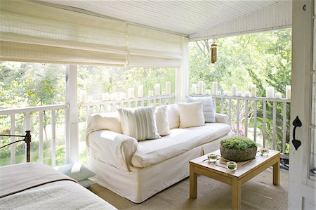 simsearch:6118-07351758,k - A veranda or shaded porch of a house in the woods, with cream sofa and candles along the balustrade. Foto de stock - Sin royalties Premium, Código: 6118-07351767