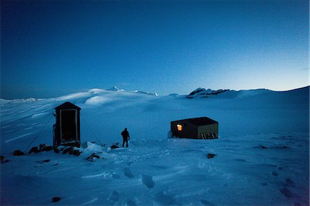 A refuge on the  Wapta Traverse, a 4 day hut-to-hut ski tour. A skier leaves the main hut to use the outhouse restroom. Stock Photo - Premium Royalty-Free, Code: 6118-07351702