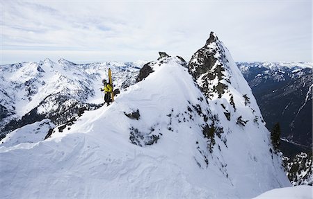 A skier stands on a ridgeline before skiing The Slot on Snoqualmie Peak in the Cascades range, Washington state, USA. Foto de stock - Royalty Free Premium, Número: 6118-07351708