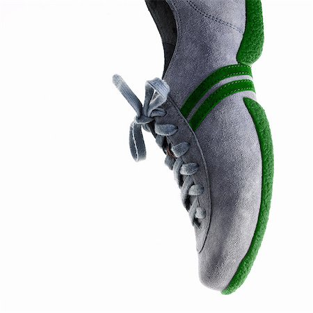 schuhe - A single sneaker or trainer shoe with laces and green sole. Stockbilder - Premium RF Lizenzfrei, Bildnummer: 6118-07351714