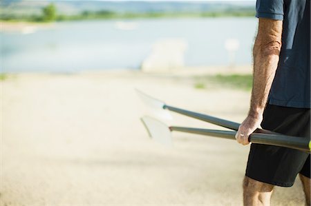 simsearch:6118-07351273,k - A middle-aged man carrying oars and walking down a pontoon towards the river. Photographie de stock - Premium Libres de Droits, Code: 6118-07351856