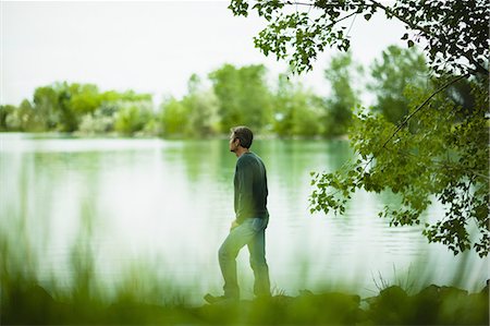 simsearch:6118-07351879,k - A man standing alone looking into the distance across the water, deep in thought. Stock Photo - Premium Royalty-Free, Code: 6118-07351873