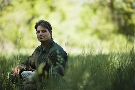 simsearch:6118-07352427,k - A man outdoors, sitting on the ground, looking thoughtful and contemplative. Photographie de stock - Premium Libres de Droits, Code: 6118-07351888