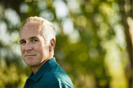 simsearch:6118-07351875,k - A mature man wearing a green shirt, in woodland. Stock Photo - Premium Royalty-Free, Code: 6118-07351892