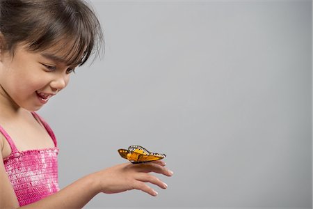 A child with a butterfly on her hand, keeping very still. Photographie de stock - Premium Libres de Droits, Code: 6118-07351829