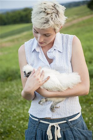 simsearch:693-03303754,k - A young girl, teenager, holding a chicken with white feathers in her arms. Photographie de stock - Premium Libres de Droits, Code: 6118-07351942