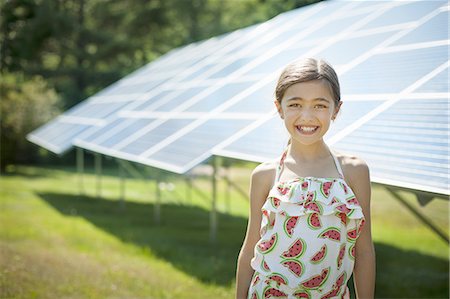 enjeux écologiques - A child in the fresh open air on a sunny day, beside solar panels at a farm. Photographie de stock - Premium Libres de Droits, Code: 6118-07351944