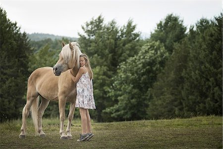 A young girl with a palomino pony in a field. Stock Photo - Premium Royalty-Free, Code: 6118-07352053