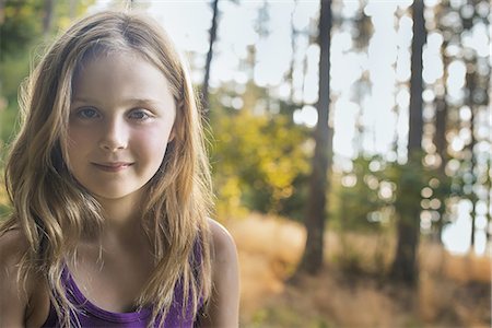 simsearch:6118-07352035,k - A young girl with long blonde hair in woodland in the fresh air, looking at the camera. Stockbilder - Premium RF Lizenzfrei, Bildnummer: 6118-07352091