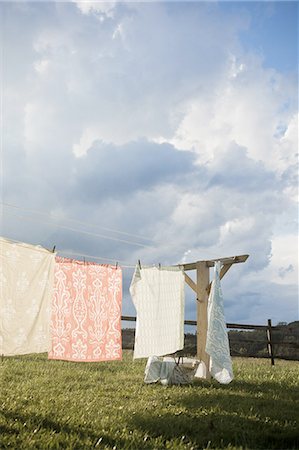 A washing line with household linens and washing hung out to dry in the fresh air. Stock Photo - Premium Royalty-Free, Code: 6118-07352003