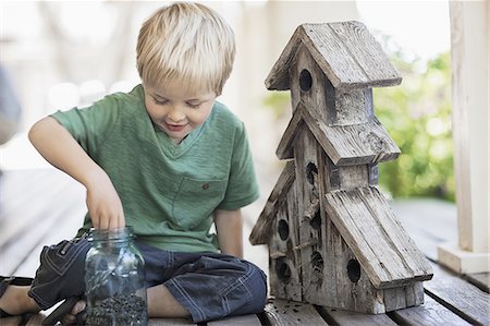 simsearch:6118-07352198,k - A child examining a bug box on a porch. Stock Photo - Premium Royalty-Free, Code: 6118-07352163