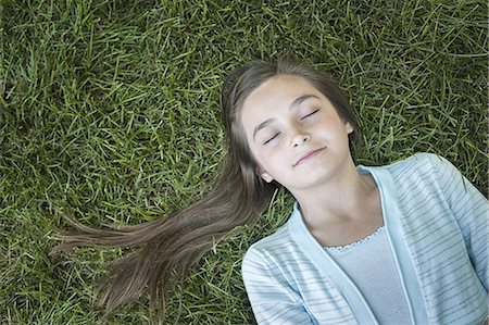 A girl with long hair fanned out, asleep on the grass. Photographie de stock - Premium Libres de Droits, Code: 6118-07352168