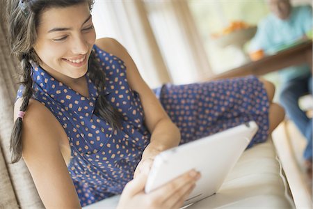 A young woman in a traditional home using an electronic personal notepad computer. Stock Photo - Premium Royalty-Free, Code: 6118-07352109