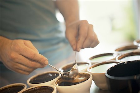 simsearch:6118-07352121,k - The sampling procedure in a coffee processing shed, where staff make coffee in small pots and sample the taste to test the blend. Stock Photo - Premium Royalty-Free, Code: 6118-07352134