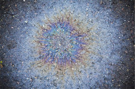 simsearch:614-06442945,k - Spilled oil on a road, creating a radiating pattern of multicoloured effect. Stockbilder - Premium RF Lizenzfrei, Bildnummer: 6118-07352253