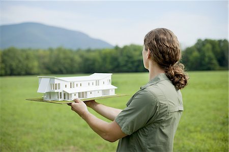 pferdeschwanz (frisur) - A rural scene and mountain range, and a person holding a scale model of a new building. Stockbilder - Premium RF Lizenzfrei, Bildnummer: 6118-07352225
