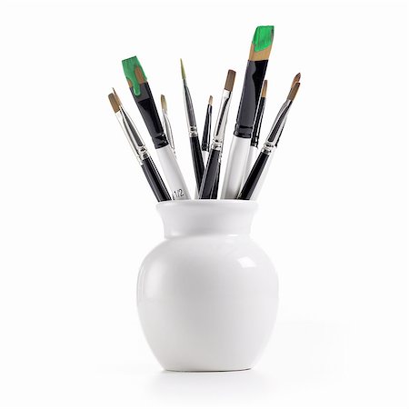 A white china pot full of paintbrushes, some still loaded with green paint. Stock Photo - Premium Royalty-Free, Code: 6118-07352328