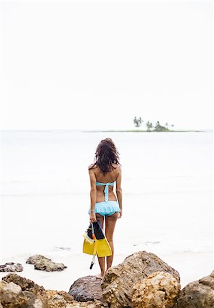 snorkeling - A young woman holding snorkelling gear on the Samana Peninsula in the Dominican Republic. Photographie de stock - Premium Libres de Droits, Code: 6118-07352403