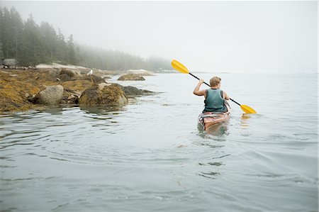 A man paddling a kayak on calm water in misty conditions. New York State, USA Photographie de stock - Premium Libres de Droits, Code: 6118-07352424