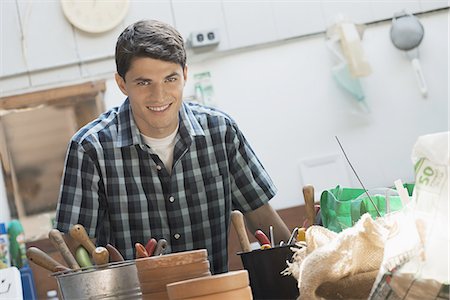 south american ethnicity - Organic Farm. A young man in a potting shed by work bench. Stock Photo - Premium Royalty-Free, Code: 6118-07352436