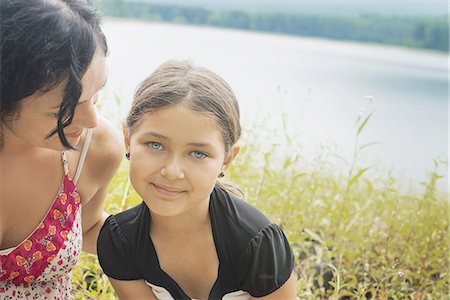 simsearch:6118-07352427,k - A mother and daughter in long grass by a lake shore. Photographie de stock - Premium Libres de Droits, Code: 6118-07352573