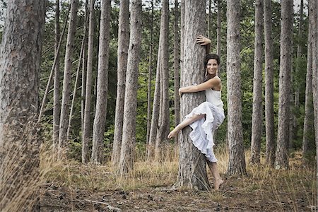 A woman dancing gracefully in the open air beside a tree in the forest. Woodstock, New York State, USA Stock Photo - Premium Royalty-Free, Code: 6118-07352576