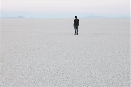 sad mans - Man standing in vast, desert landscape Stock Photo - Premium Royalty-Free, Code: 6118-07352773