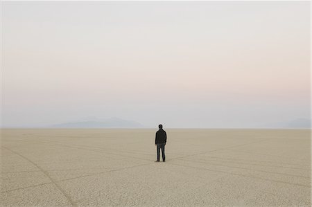 desert land - Man standing in vast, desert landscape Stock Photo - Premium Royalty-Free, Code: 6118-07352771