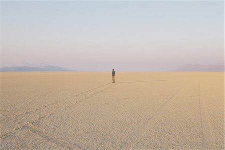 simsearch:6118-07122047,k - The figure of a man in the empty desert landscape of Black Rock desert, Nevada. Foto de stock - Royalty Free Premium, Número: 6118-07352778