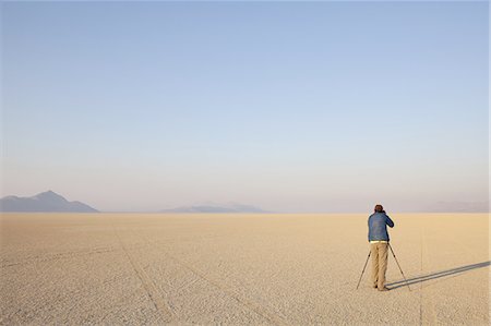 Man with camera and tripod on the flat saltpan or playa of Black Rock desert, Nevada. Foto de stock - Sin royalties Premium, Código: 6118-07352779