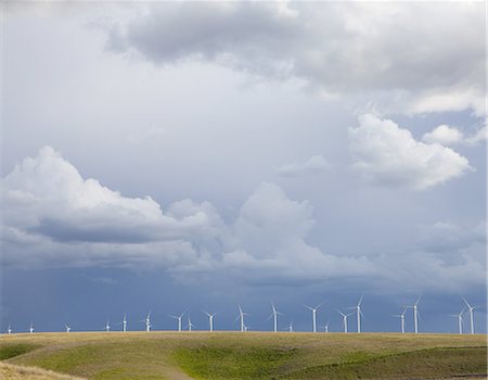 simsearch:6118-07353427,k - A line of wind turbines on a ridge, against a stormy sky. Photographie de stock - Premium Libres de Droits, Code: 6118-07352709