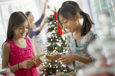 Two young girls decorating organic Christmas cookies. Fotografie stock - Premium Royalty-Free, Codice: 6118-07352965