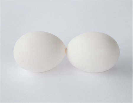 Two free range organic eggs with white shells, end to end, against a white background. Photographie de stock - Premium Libres de Droits, Code: 6118-07353047