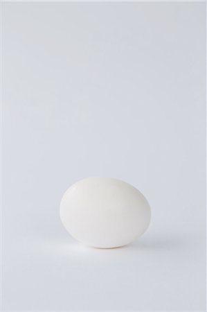 simsearch:6118-07353041,k - A single free range organic egg with a white shell against a white background. Foto de stock - Royalty Free Premium, Número: 6118-07353045