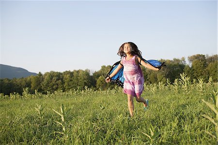 simsearch:6118-07203935,k - A young girl running across a field, wearing fabric butterfly wings. Foto de stock - Sin royalties Premium, Código: 6118-07353028