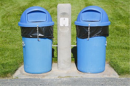 Blue trash cans on a grass sports field. Stock Photo - Premium Royalty-Free, Code: 6118-07353272