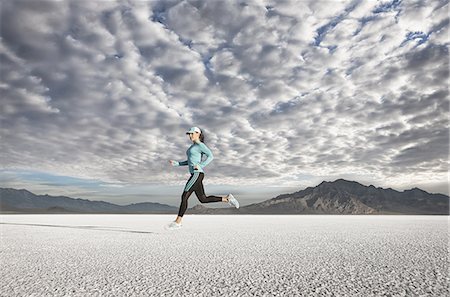 salt lake city - A young woman running through the landscape on the salt flats surface near Salt Lake city. Stock Photo - Premium Royalty-Free, Code: 6118-07353277