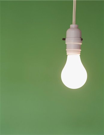 Traditional glass light bulb and switch with a white electric flex. Green background. Stock Photo - Premium Royalty-Free, Code: 6118-07353290