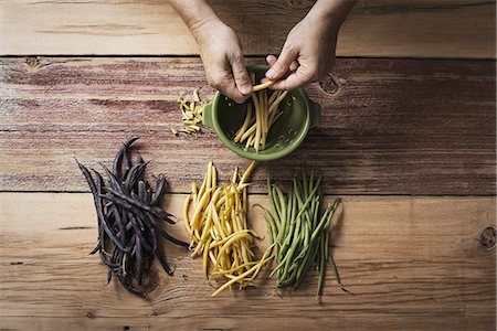 Organic green, yellow and black haricot beans, fresh vegetables being topped and tailed by a person, before cooking and eating. Stock Photo - Premium Royalty-Free, Code: 6118-07353359