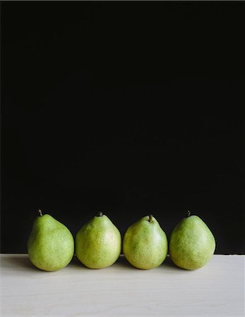 simsearch:6118-07353041,k - Row of four green Anjou pears, black background Photographie de stock - Premium Libres de Droits, Code: 6118-07353317