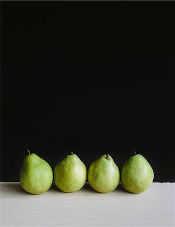 simsearch:6118-07440540,k - Row of four green Anjou pears, black background Stock Photo - Premium Royalty-Free, Code: 6118-07353317