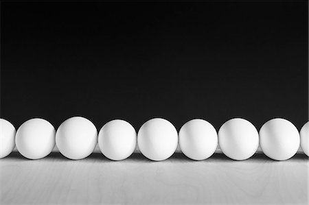 simsearch:6118-07353323,k - Row of white, free range, organic eggs, black background Photographie de stock - Premium Libres de Droits, Code: 6118-07353323