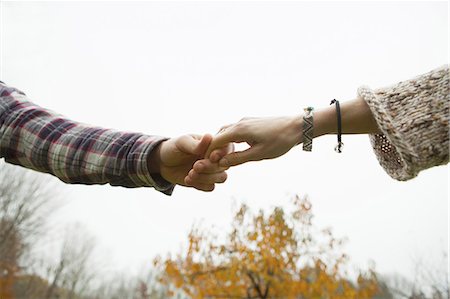 Two people holding hands, a couple outdoors. Stock Photo - Premium Royalty-Free, Code: 6118-07353444