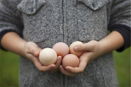 A person holding a clutch of fresh organic hen's eggs. Photographie de stock - Premium Libres de Droits, Code: 6118-07353446