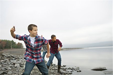 simsearch:6118-07353575,k - A day out at Ashokan lake. Three boys on the shore throwing skimmers pebbles across the water. Foto de stock - Sin royalties Premium, Código: 6118-07353571