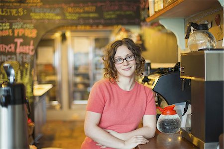A coffee shop and cafe in High Falls called The Last Bite. A woman leaning on the counter, by the coffee machine. Stock Photo - Premium Royalty-Free, Code: 6118-07353585