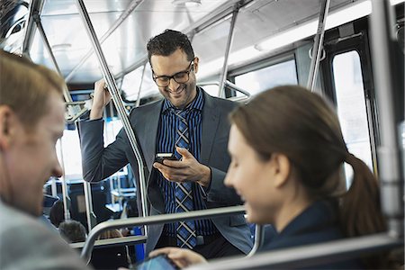 Business people in the city. Three people on the move, two men and a woman, on the bus. Photographie de stock - Premium Libres de Droits, Code: 6118-07353635