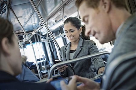 simsearch:6118-07353621,k - Business people in the city. Three people on the move, two men and a woman, on the bus. Fotografie stock - Premium Royalty-Free, Codice: 6118-07353636