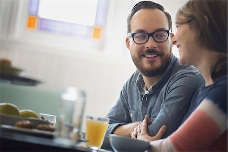 everyday people - A couple sitting in a coffeeshop smiling and talking over a cup of coffee. Stock Photo - Premium Royalty-Free, Code: 6118-07353727